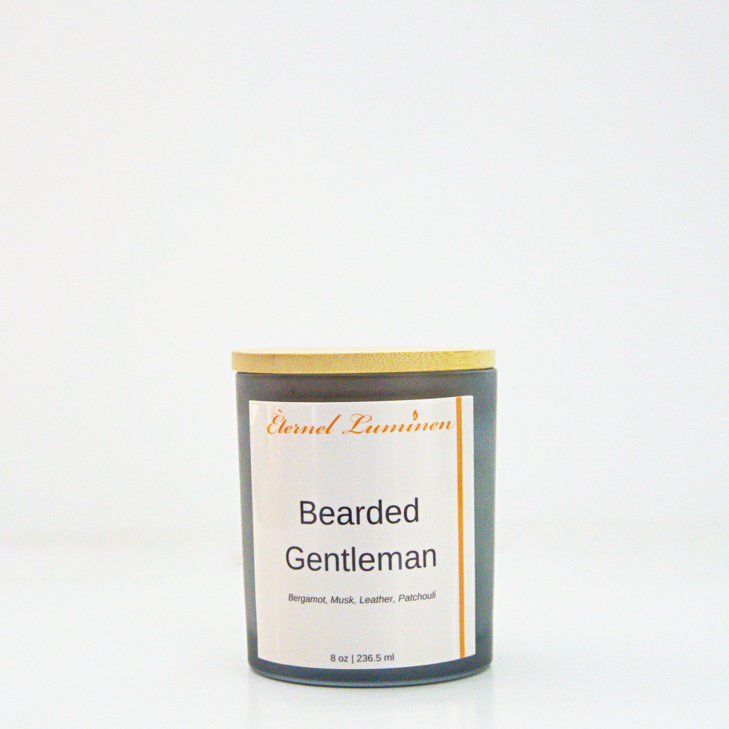 A 8 oz frosted Bearded Gentleman candle with a wooden lid sitting against a white background made by Eternel Luminen.