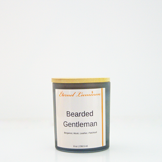 A 8 oz frosted Bearded Gentleman candle with a wooden lid sitting against a white background made by Eternel Luminen.