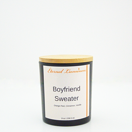 A 8 oz frosted Boyfriend Sweater candle with a wooden lid sitting against a white background made by Eternel Luminen.
