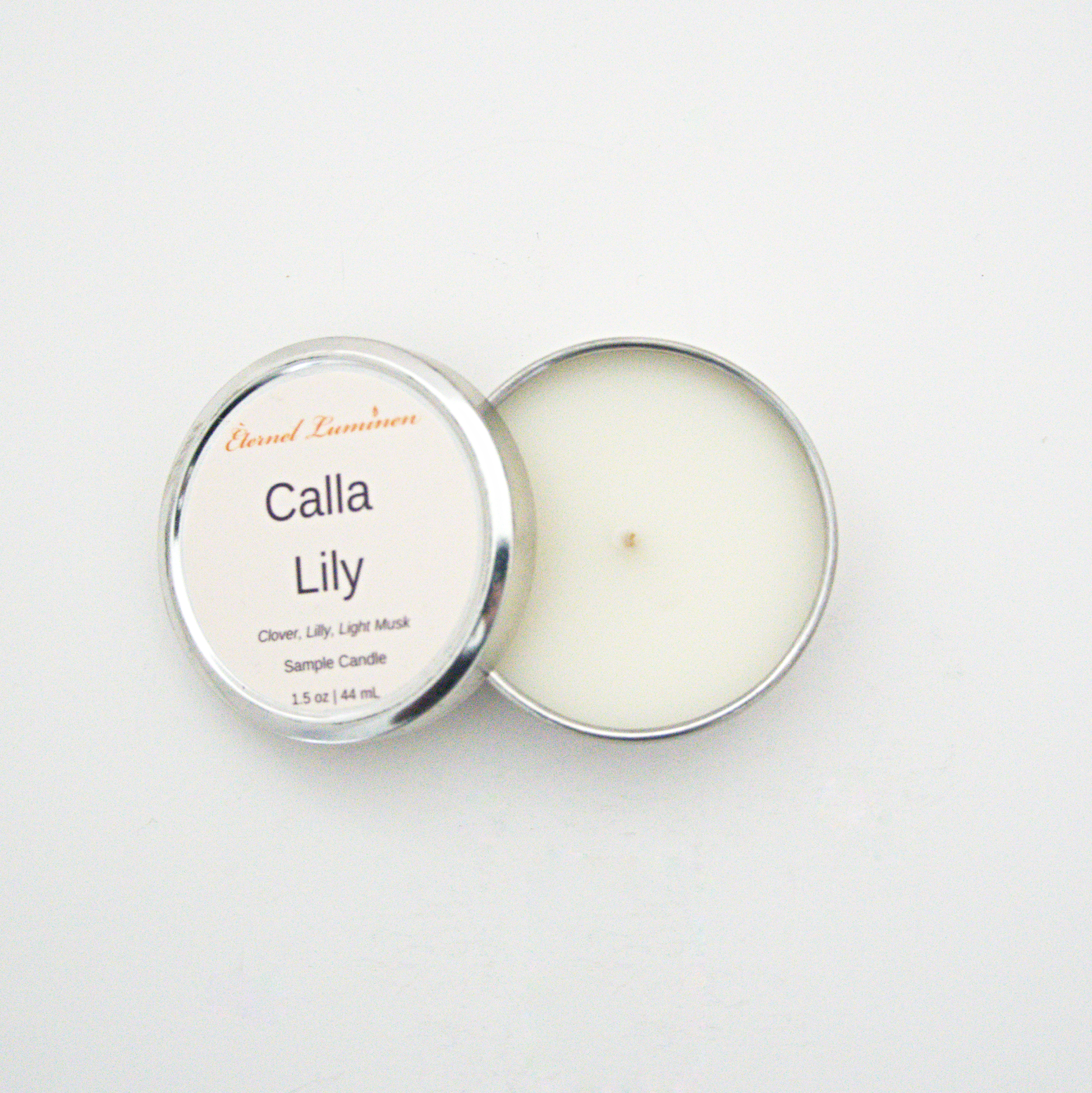 A 1.5oz Calla Lily sample candle in a tin jar with the lid off sitting against a white background made by Eternel Luminen.