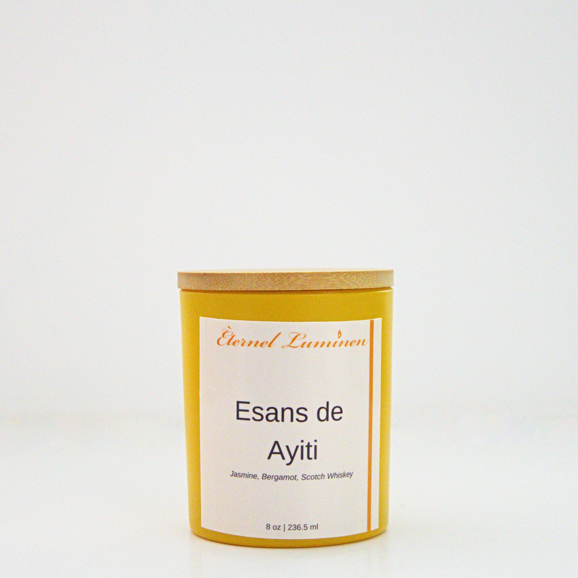 A 8 oz frosted Esans de Ayiti candle with a wooden lid sitting against a white background made by Eternel Luminen.
