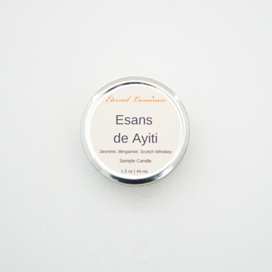 A 1.5oz Esans de Ayiti sample candle in a tin jar sitting against a white background made by Eternel Luminen