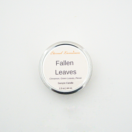 A 1.5oz Fallen Leaves sample candle in a tin jar sitting against a white background made by Eternel Luminen