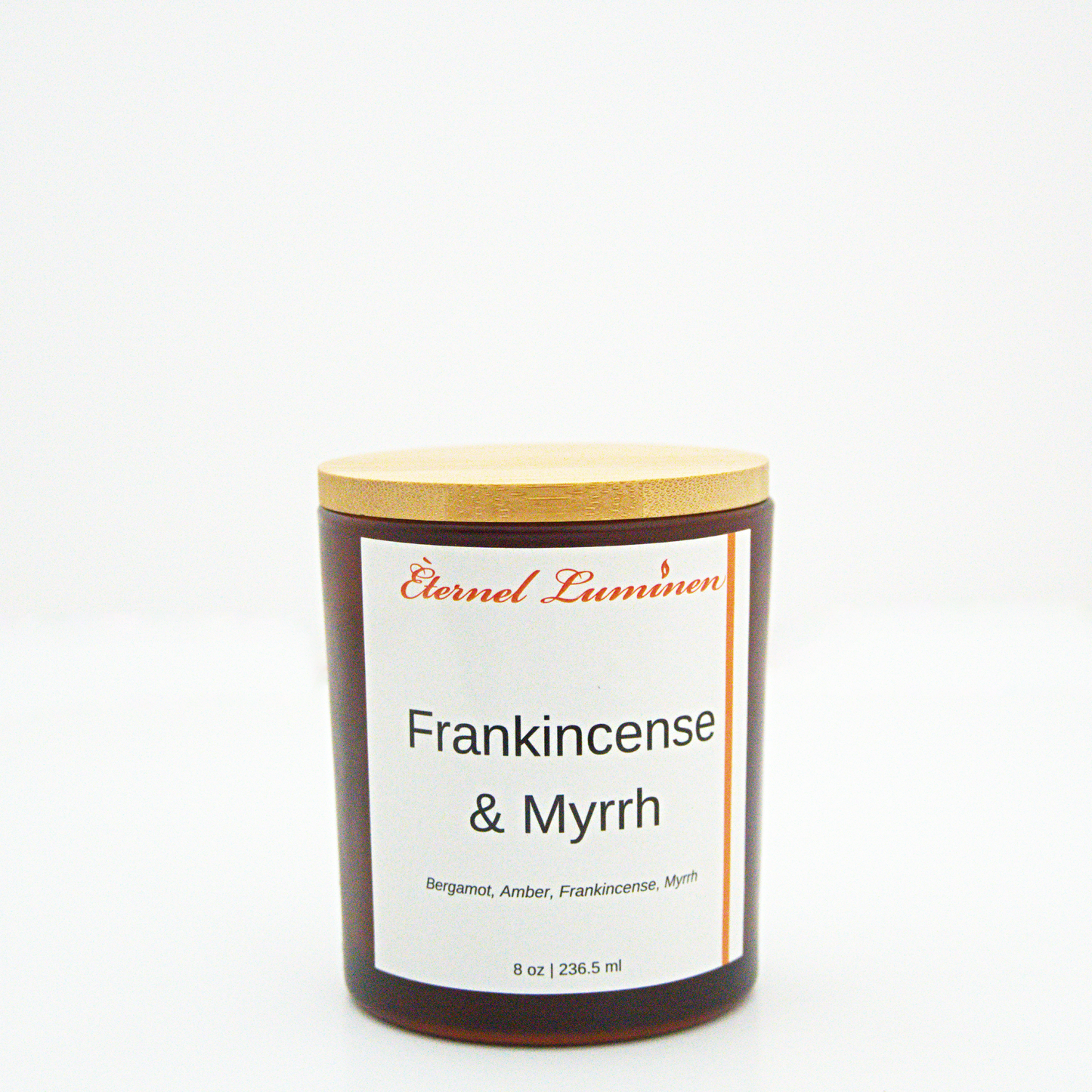 A 8 oz frankincense & myrrh frosted candle with a wooden lid sitting against a white background made by Eternel Luminen.