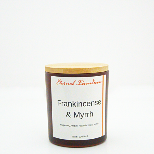 A 8 oz frankincense & myrrh frosted candle with a wooden lid sitting against a white background made by Eternel Luminen.