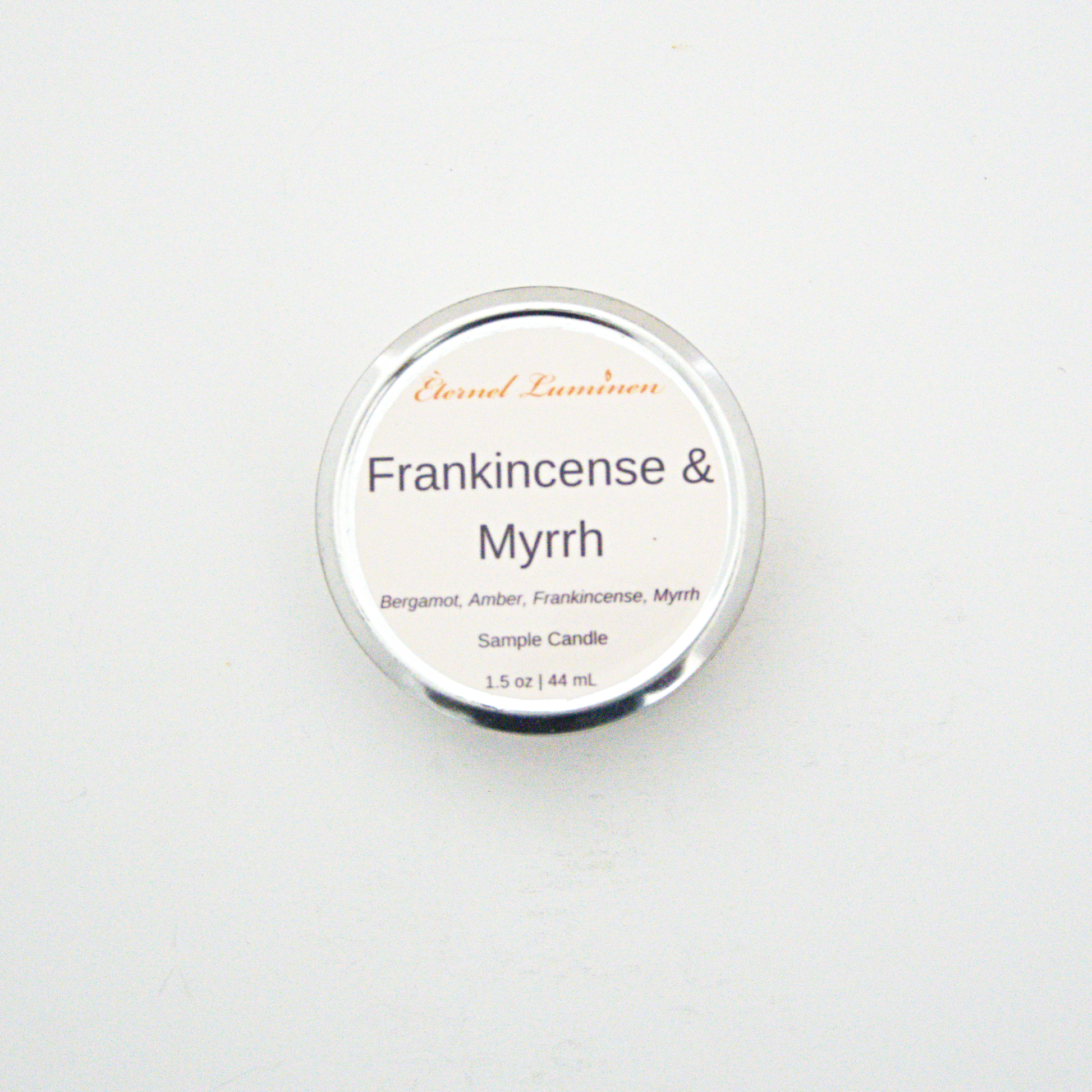 A 1.5oz Frankincense & Myrrh sample candle in a tin jar sitting against a white background made by Eternel Luminen