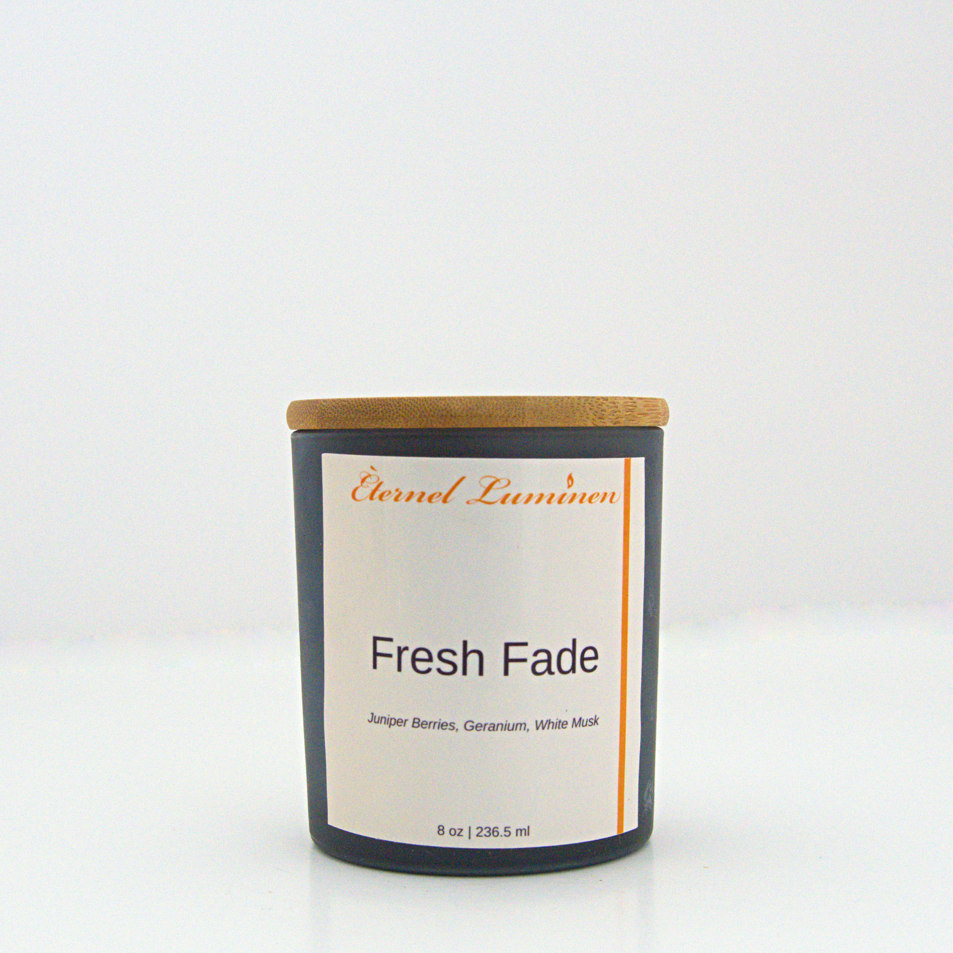 A 8 oz Fresh Fade frosted candle with a wooden lid sitting against a white background made by Eternel Luminen.