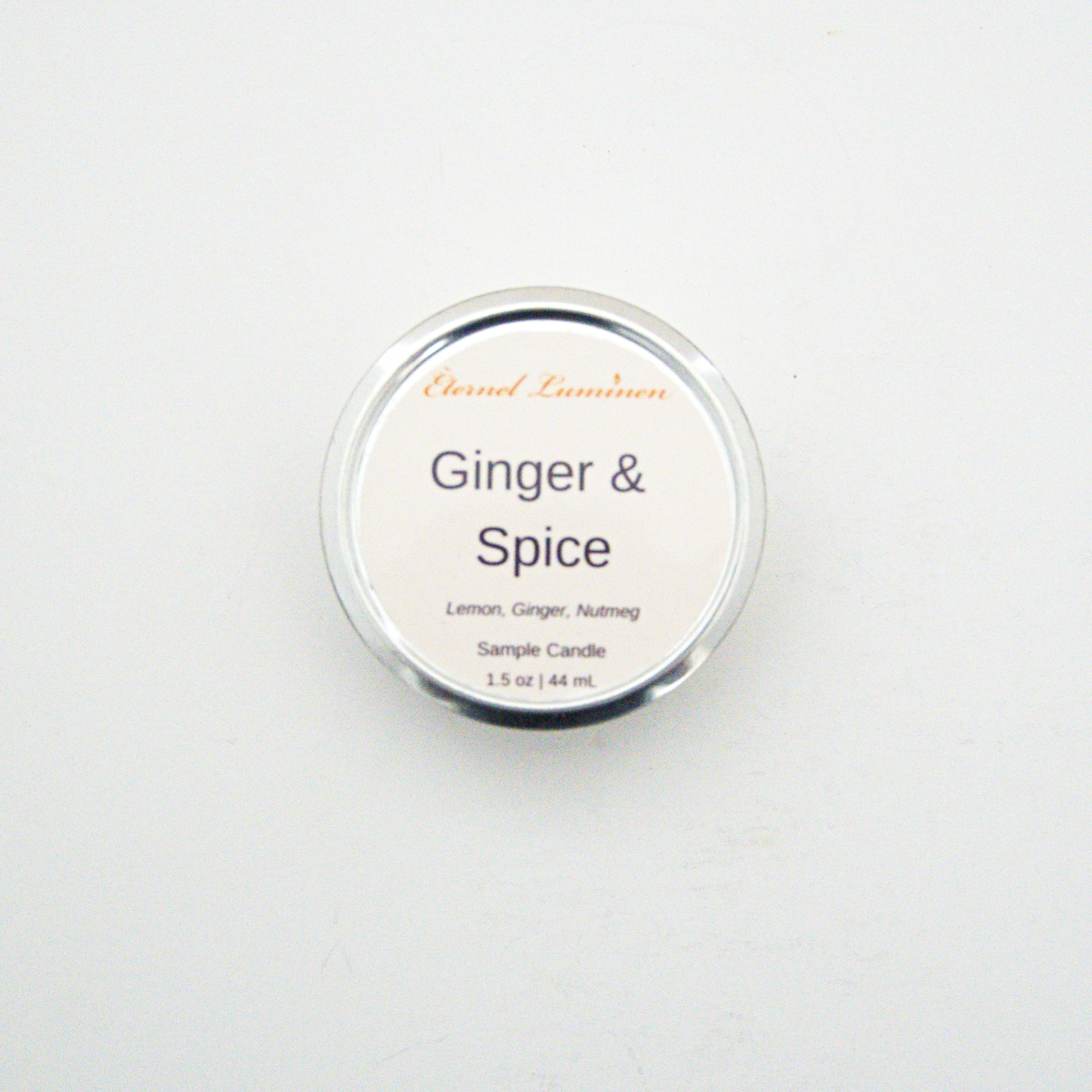 A 1.5oz Ginger & Spice sample candle in a tin jar sitting against a white background made by Eternel Luminen