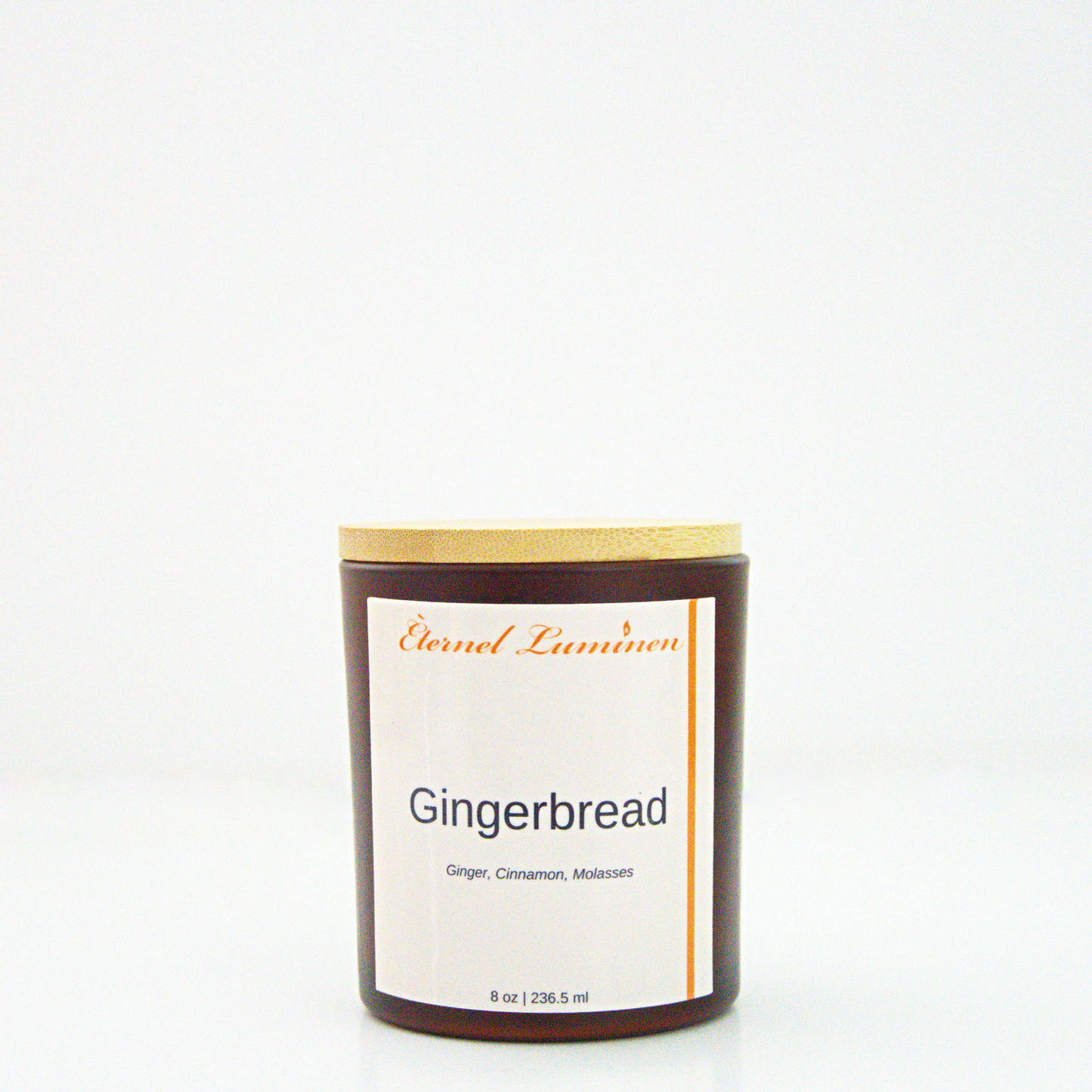 A 8 oz Gingerbread frosted candle with a wooden lid sitting against a white background made by Eternel Luminen.