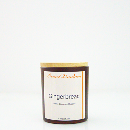 A 8 oz Gingerbread frosted candle with a wooden lid sitting against a white background made by Eternel Luminen.