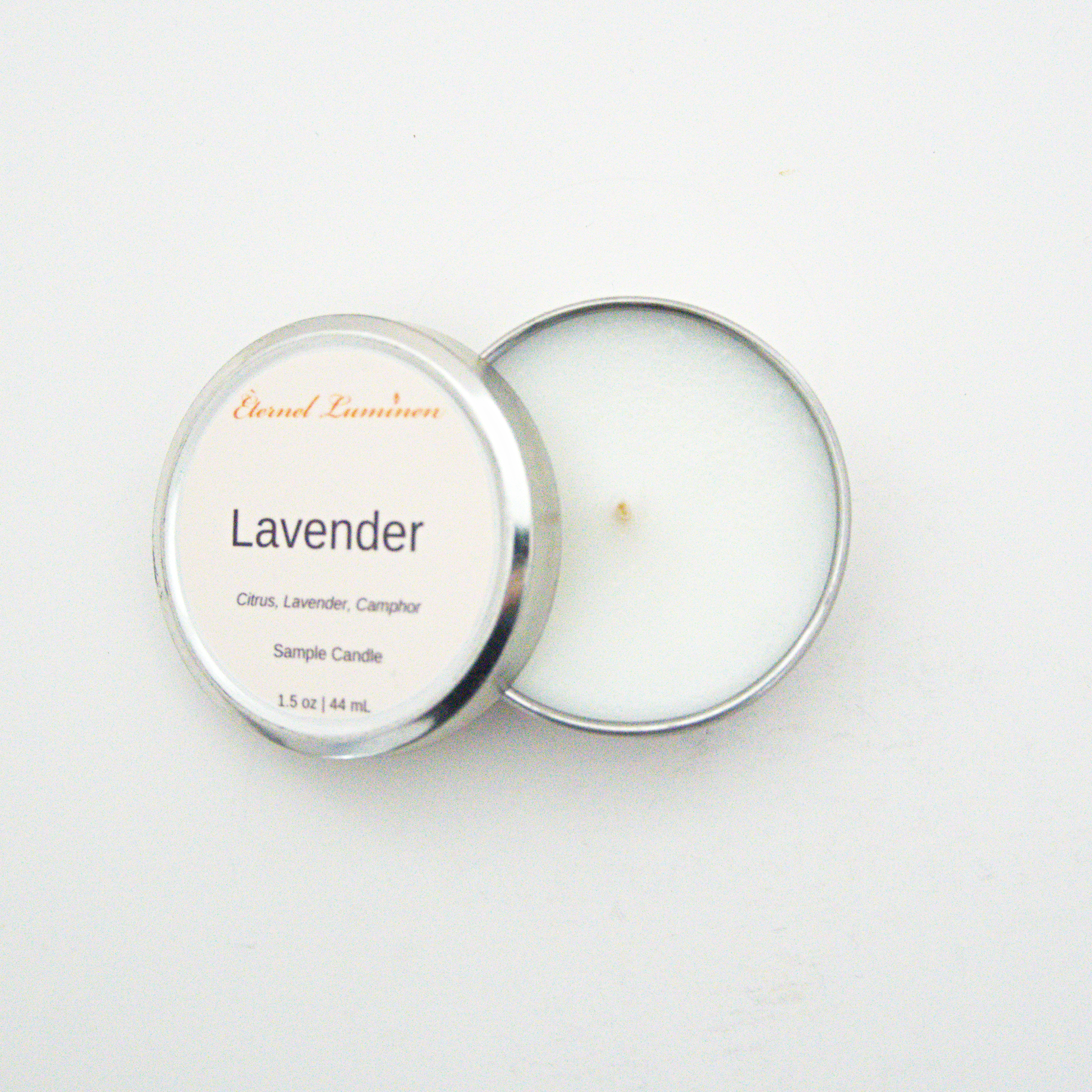 A 1.5oz Lavender sample candle in a tin jar with the lid off sitting against a white background made by Eternel Luminen.