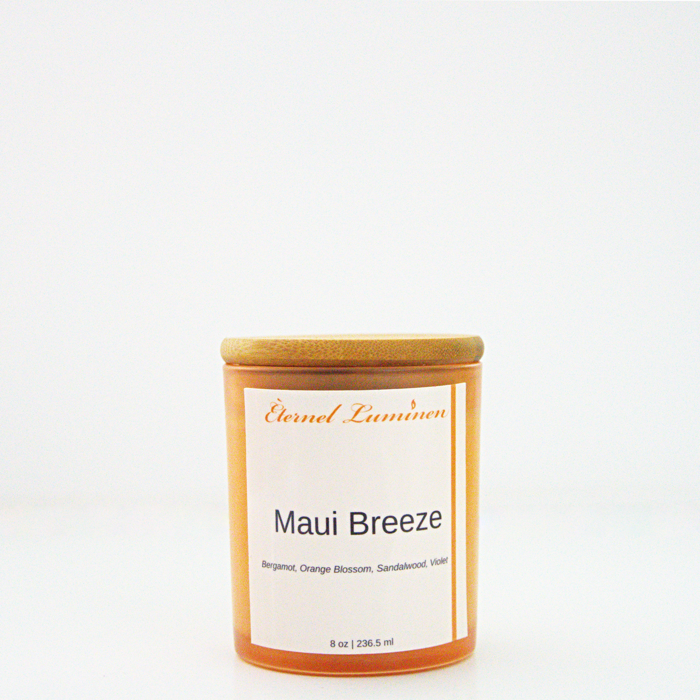 A 8 oz frosted Maui Breeze candle with a wooden lid sitting against a white background made by Eternel Luminen.