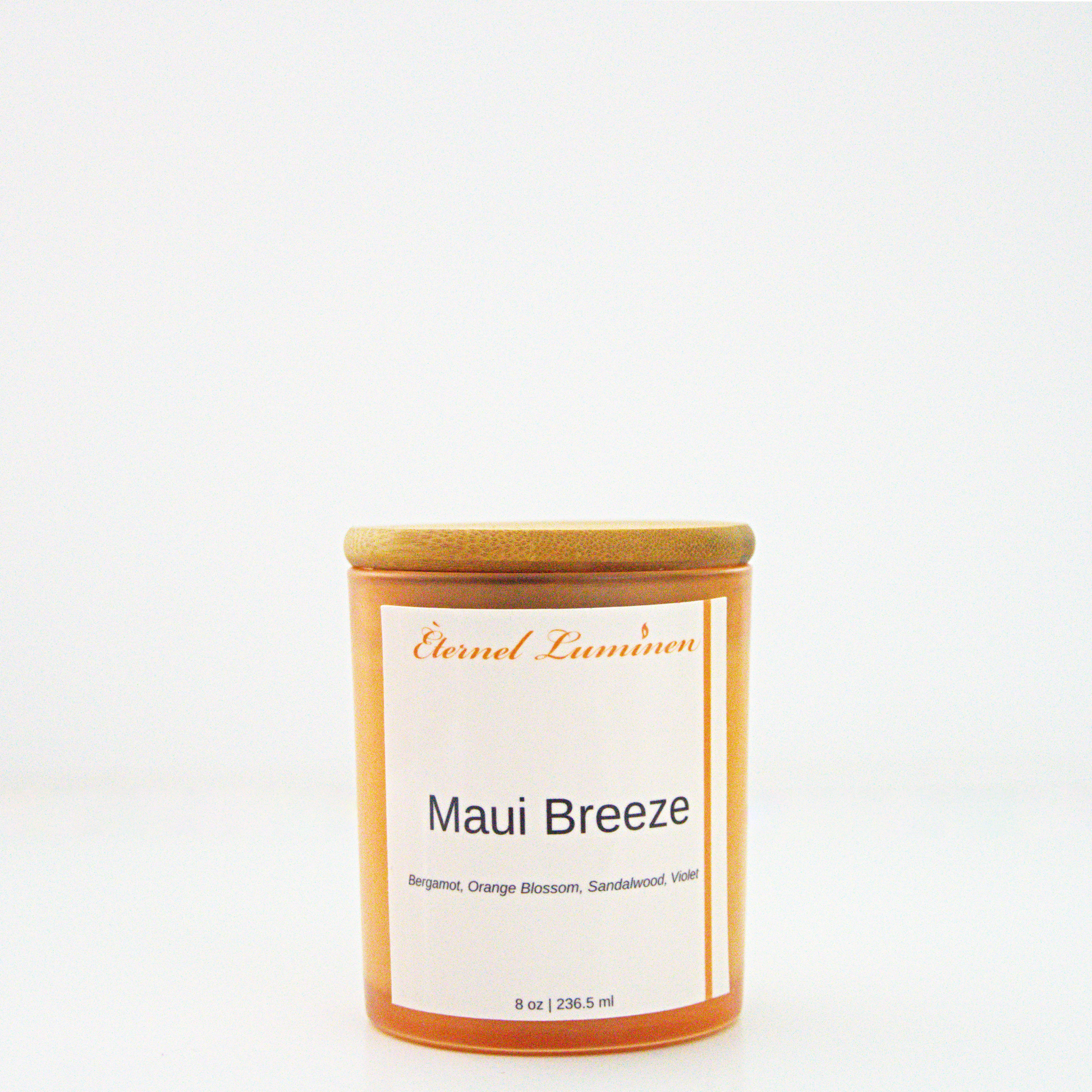 A 8 oz frosted Maui Breeze candle with a wooden lid sitting against a white background made by Eternel Luminen.