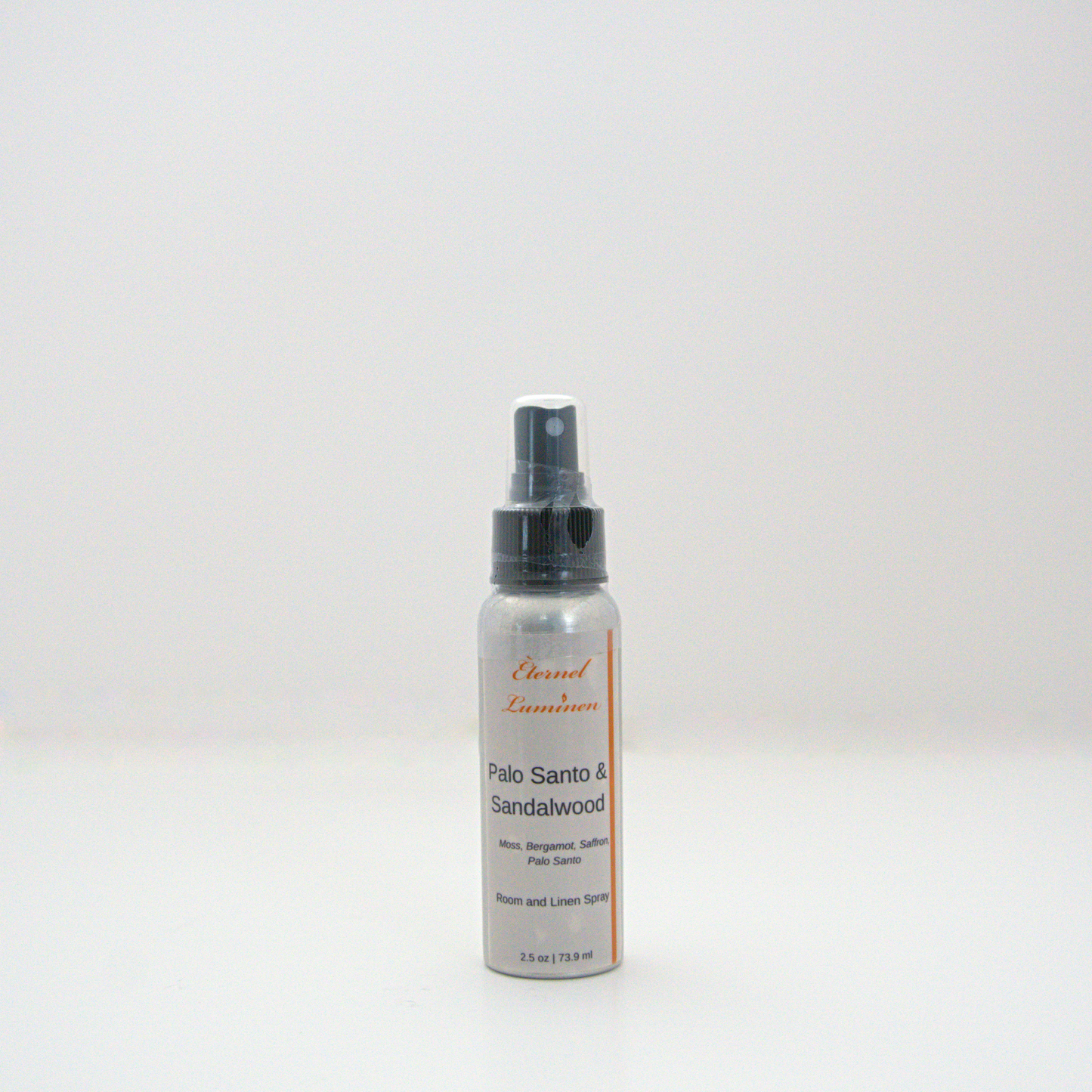 A 2.5oz Palo Santo & Sandalwood room & linen spray sitting against a white background made by Eternel Luminen.