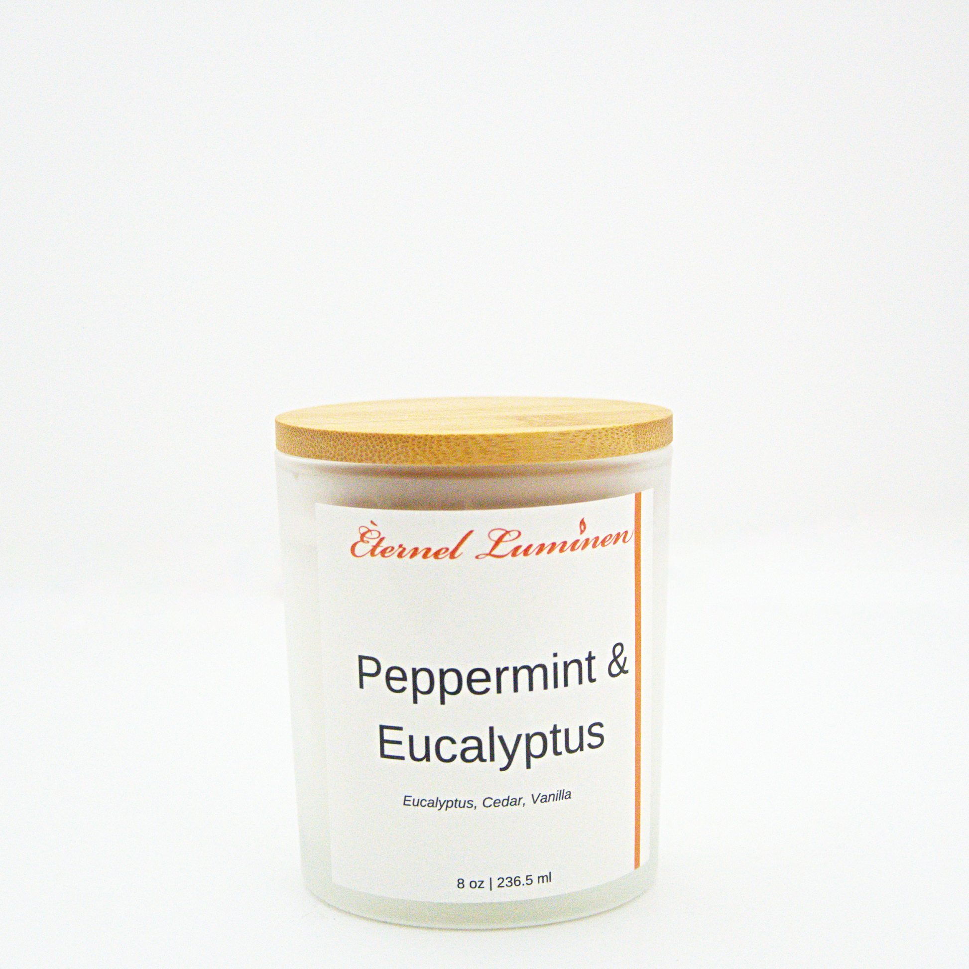 A 8 oz peppermint and eucalyptus frosted candle with a wooden lid sitting against a white background made by Eternel Luminen.