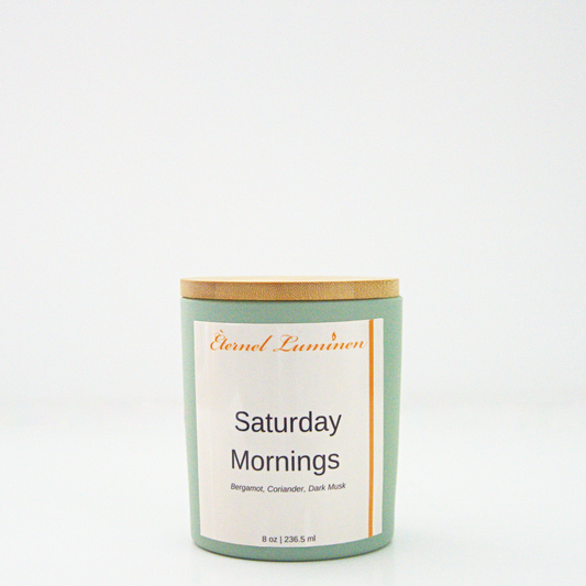 A 8 oz frosted Saturday Mornings candle with a wooden lid sitting against a white background made by Eternel Luminen.