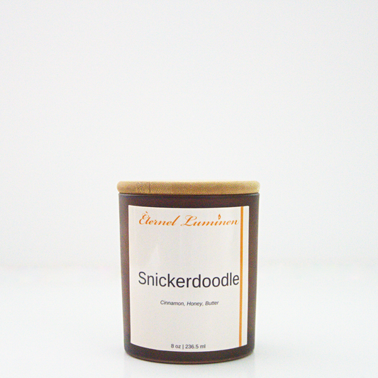 A 8oz snickerdoodle frosted candle with a wooden lid sitting against a white background made by Eternel Luminen.