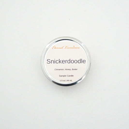 A 1.5oz Snickerdoodle sample candle in a tin jar sitting against a white background made by Eternel Luminen