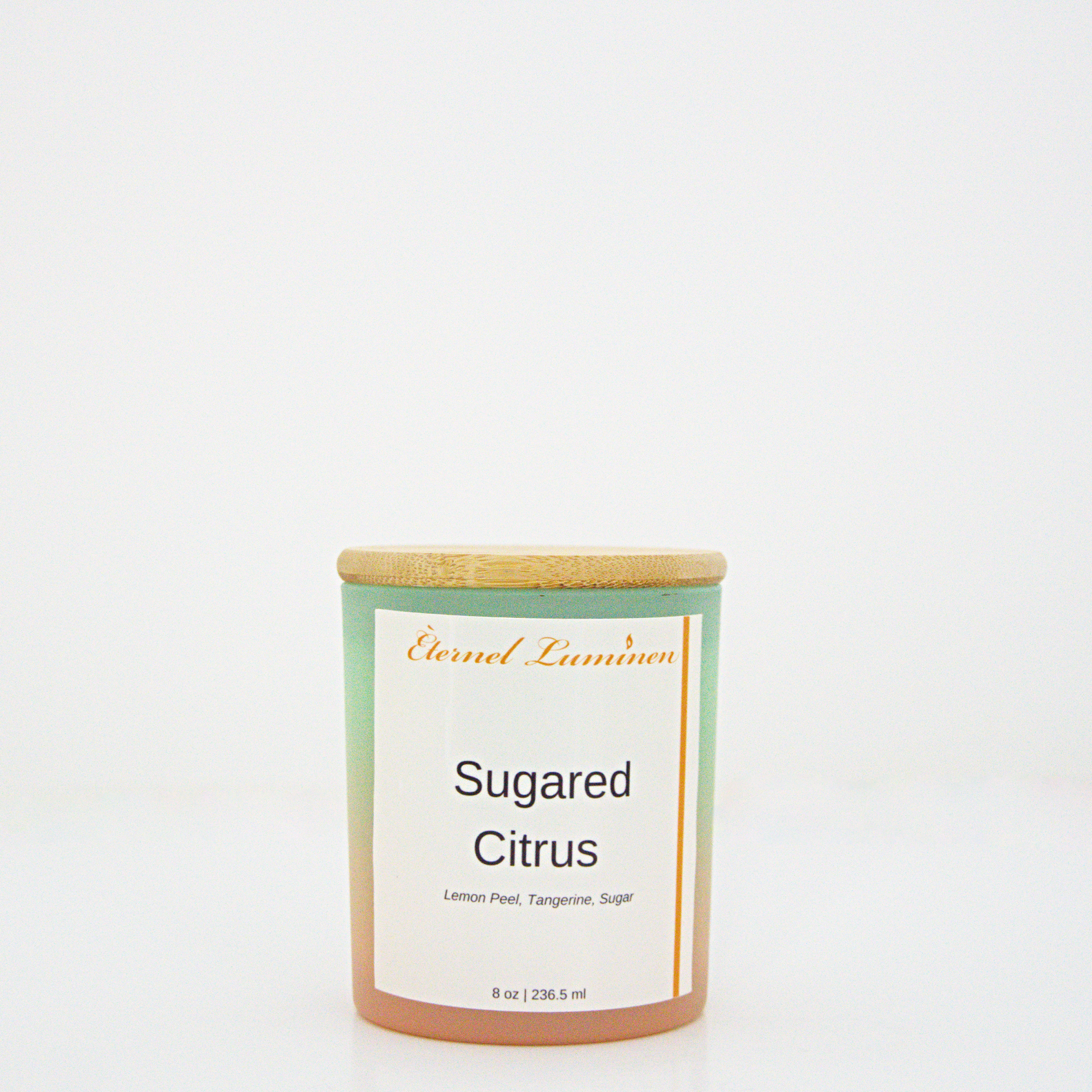 A 8 oz Sugared citrus frosted candle with a wooden lid sitting against a white background made by Eternel Luminen.