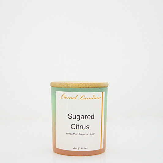 A 8 oz Sugared citrus frosted candle with a wooden lid sitting against a white background made by Eternel Luminen.