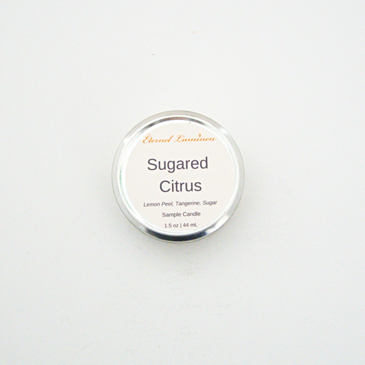 A 1.5oz Sugared Citrus sample candle in a tin jar sitting against a white background made by Eternel Luminen.