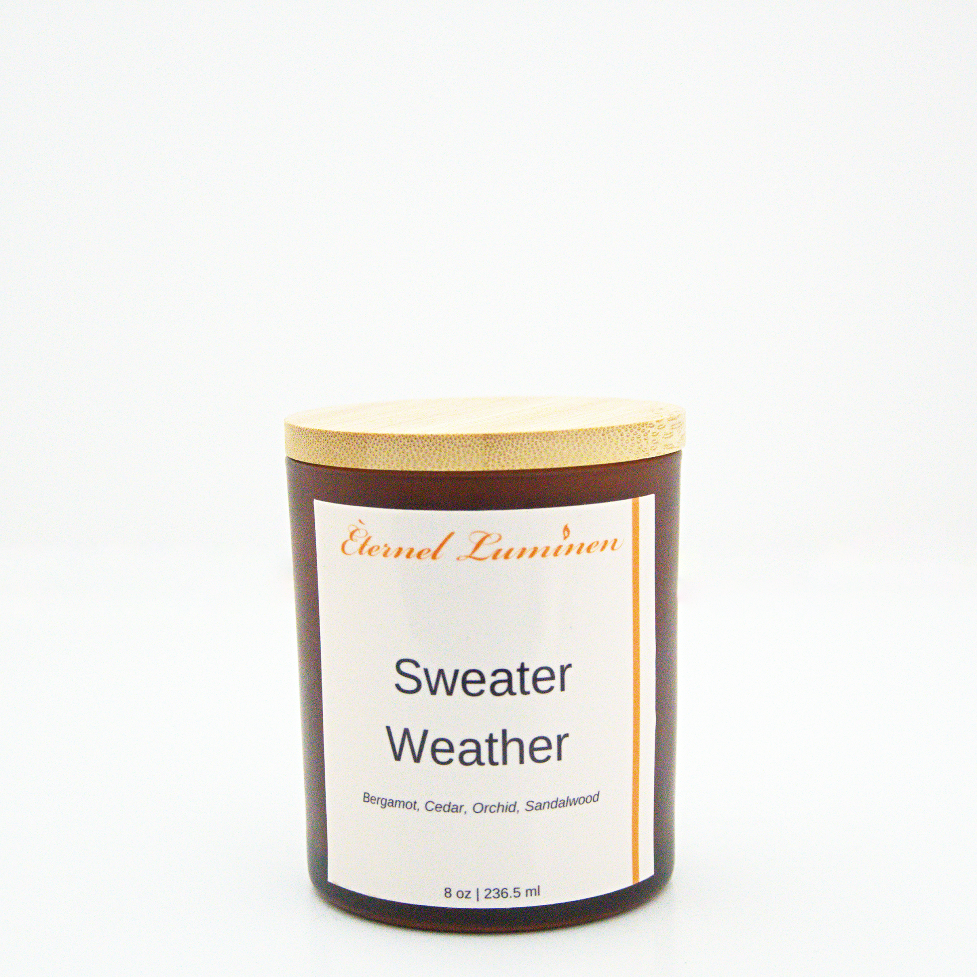 A 8 oz frosted Sweater Weather candle with a wooden lid sitting against a white background made by Eternel Luminen.