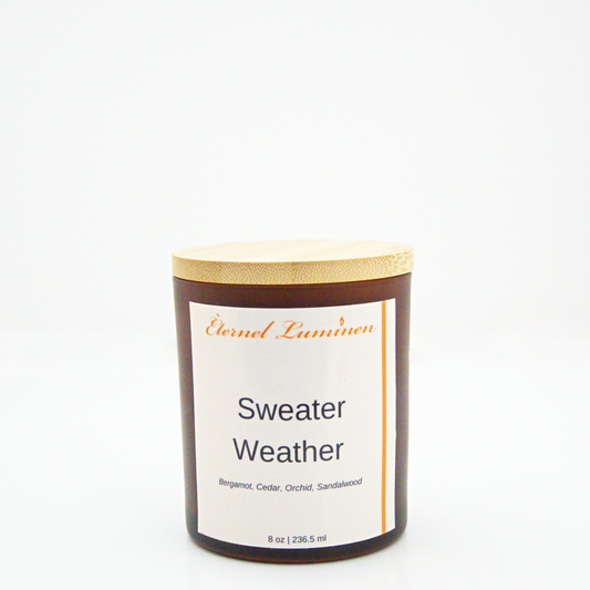 A 8 oz frosted Sweater Weather candle with a wooden lid sitting against a white background made by Eternel Luminen.
