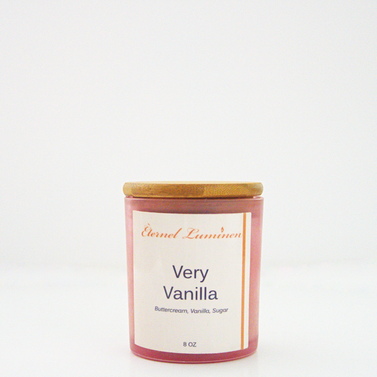 A 8 oz frosted Very Vanilla candle with a wooden lid sitting against a white background made by Eternel Luminen.