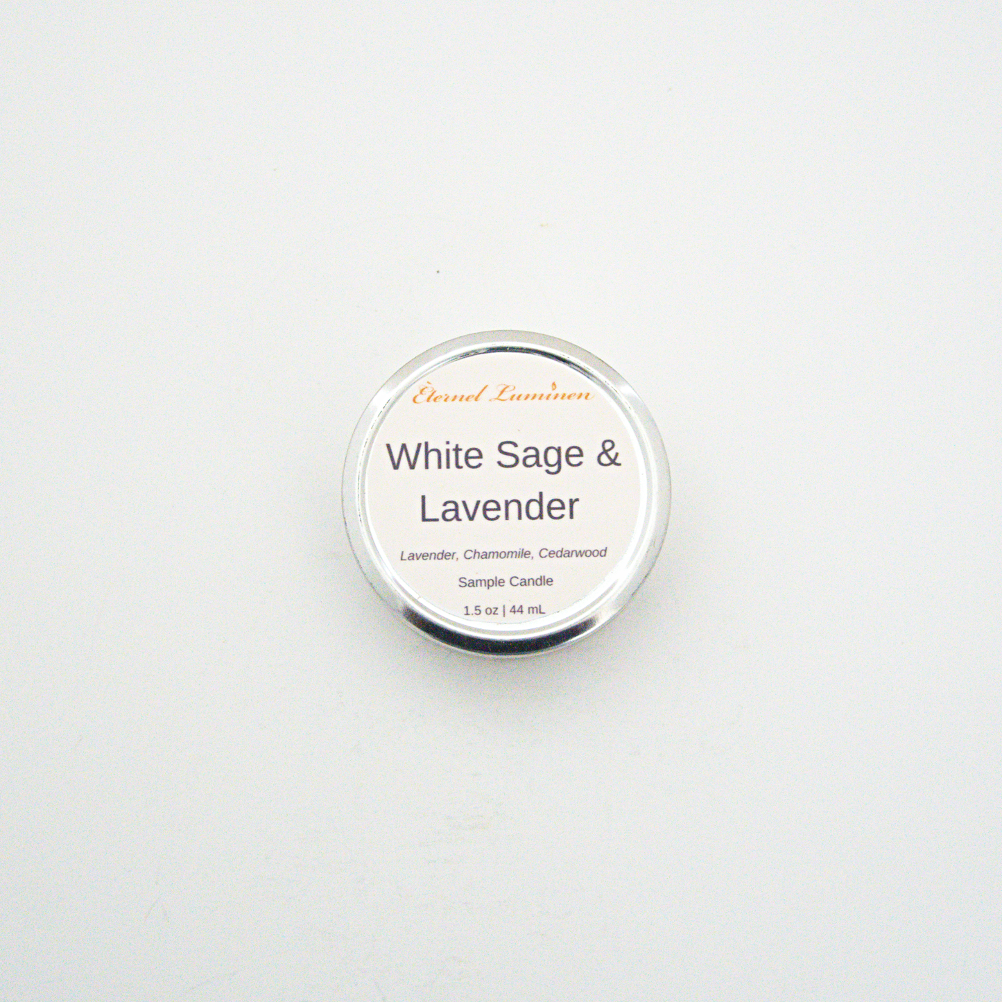 A 1.5oz White Sage & Lavender sample candle in a tin jar sitting against a white background made by Eternel Luminen