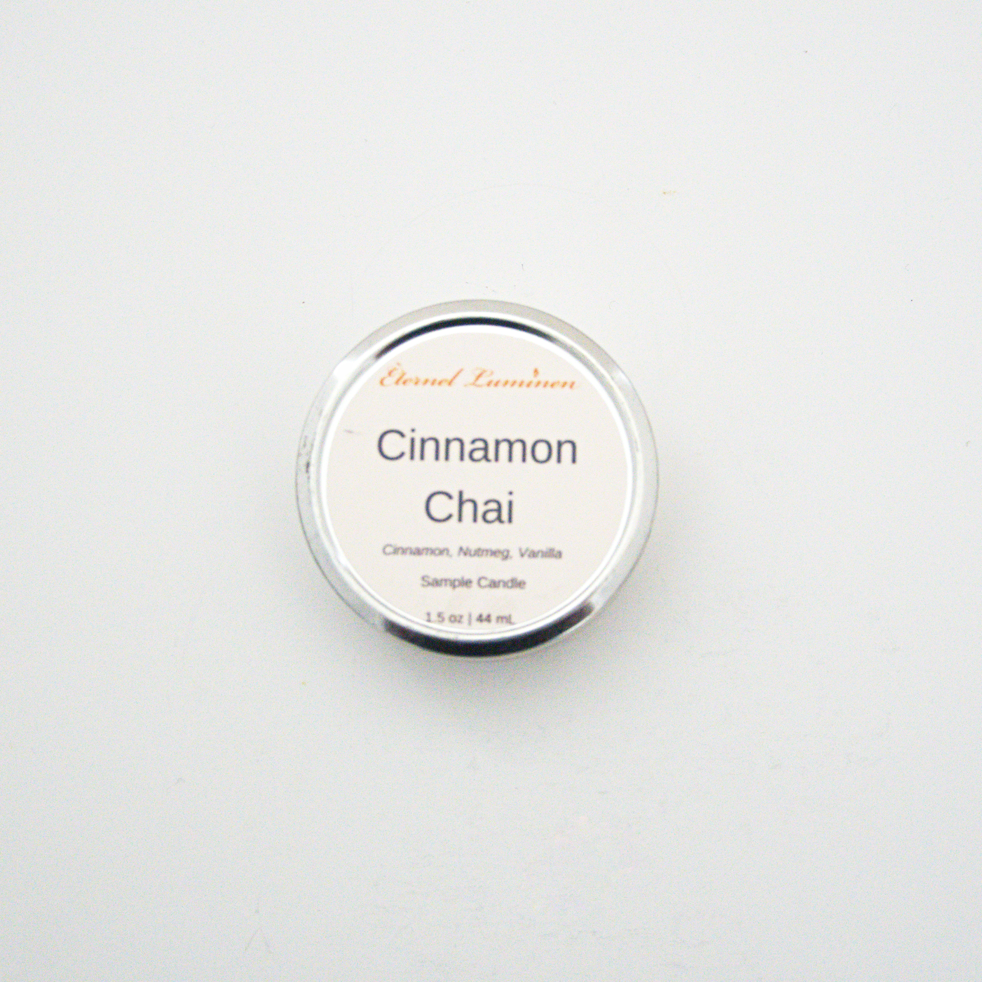 A 1.5oz Cinnamon Chai sample candle in a tin jar sitting against a white background made by Eternel Luminen