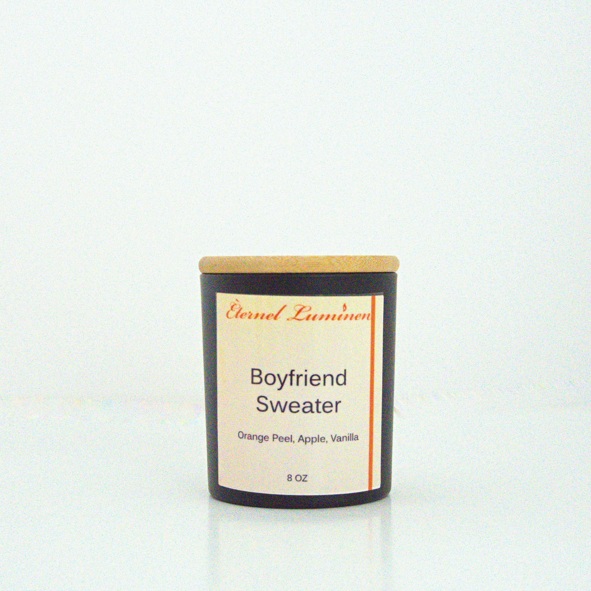 A 8 oz frosted Boyfriend Sweater candle with a wooden lid sitting against a white background made by Eternel Luminen.