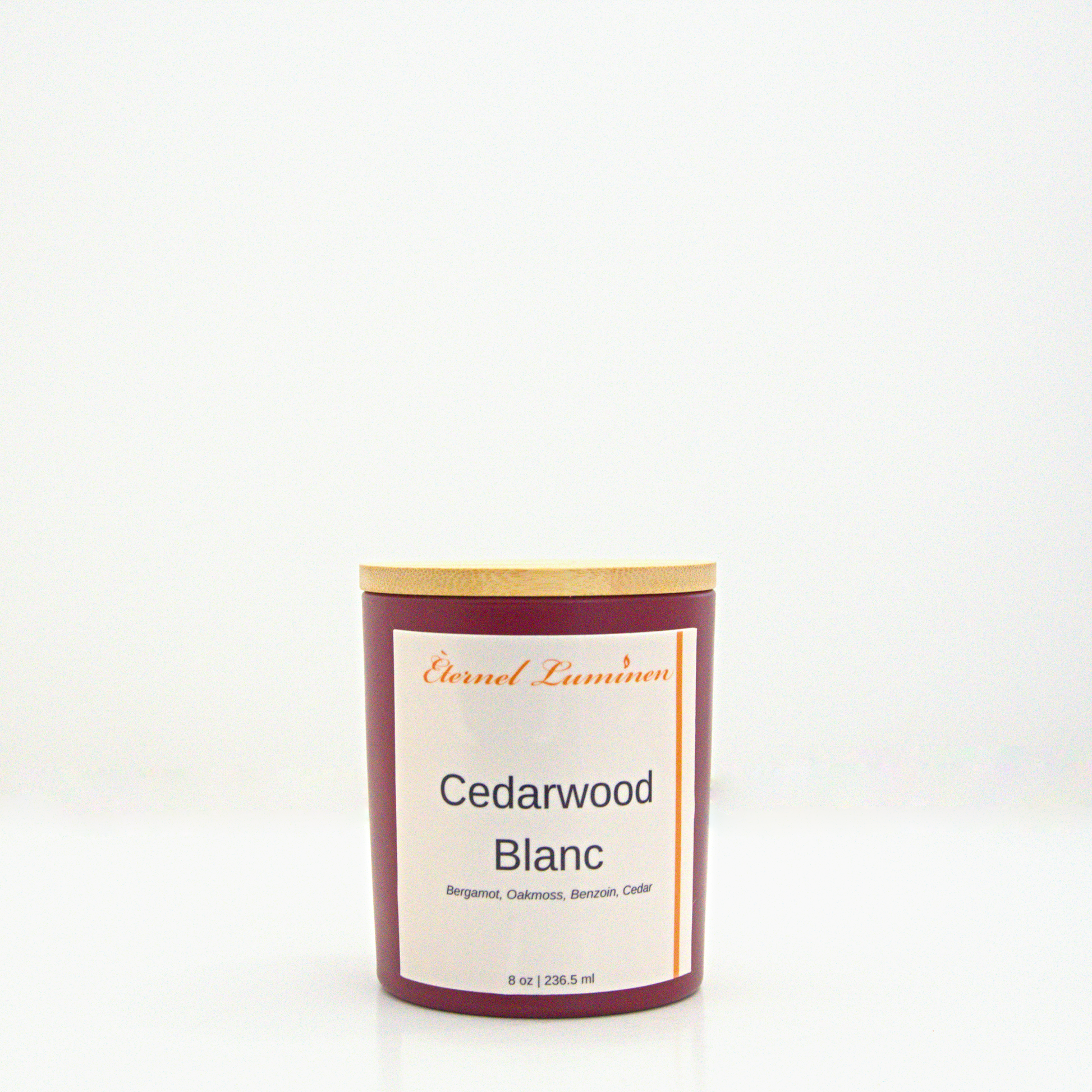A 8oz frosted Cedarwood Blanc candle with a wooden lid sitting against a white background