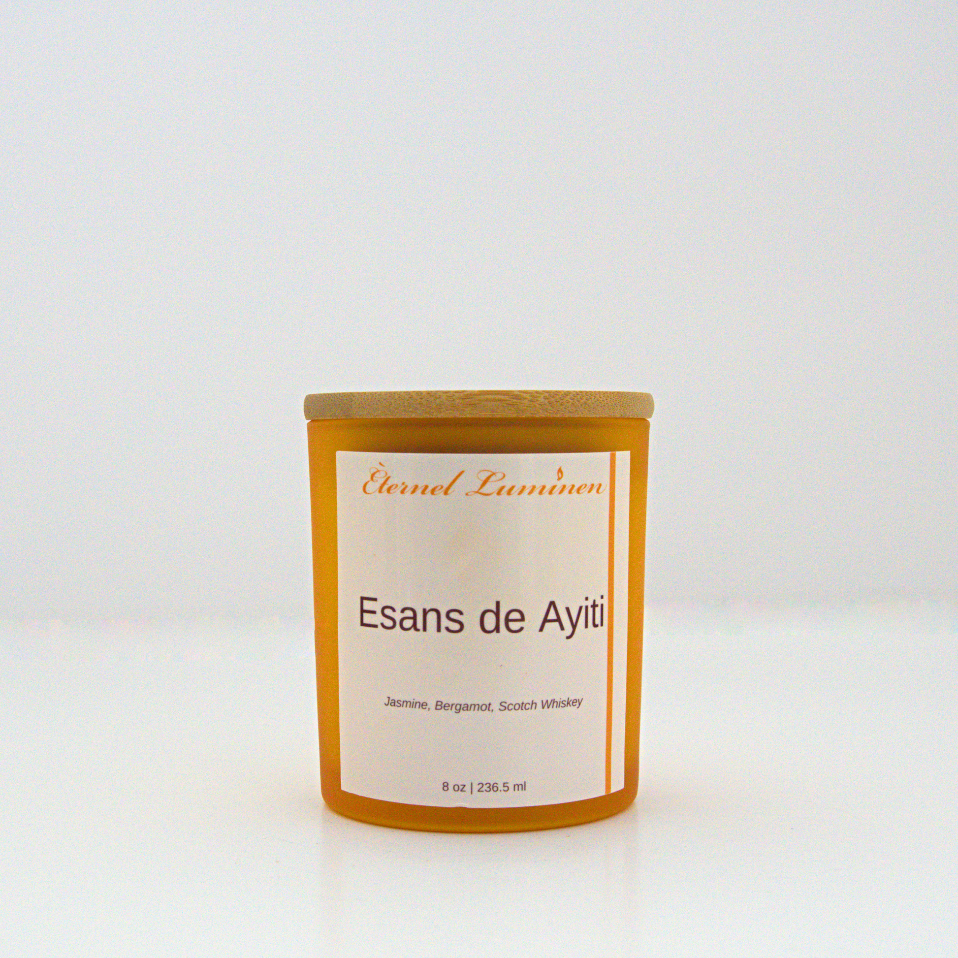 A 8 oz frosted Esans de Ayiti candle with a wooden lid sitting against a white background made by Eternel Luminen.