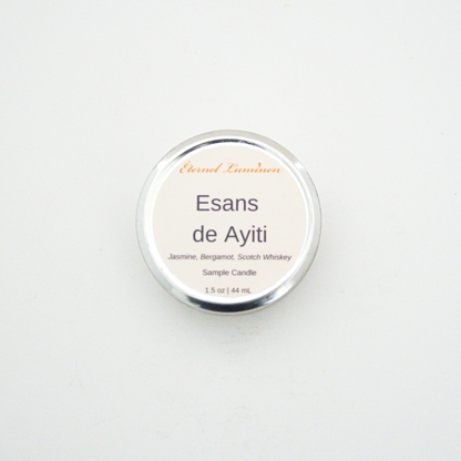 A 1.5oz Esans de Ayiti sample candle in a tin jar sitting against a white background made by Eternel Luminen