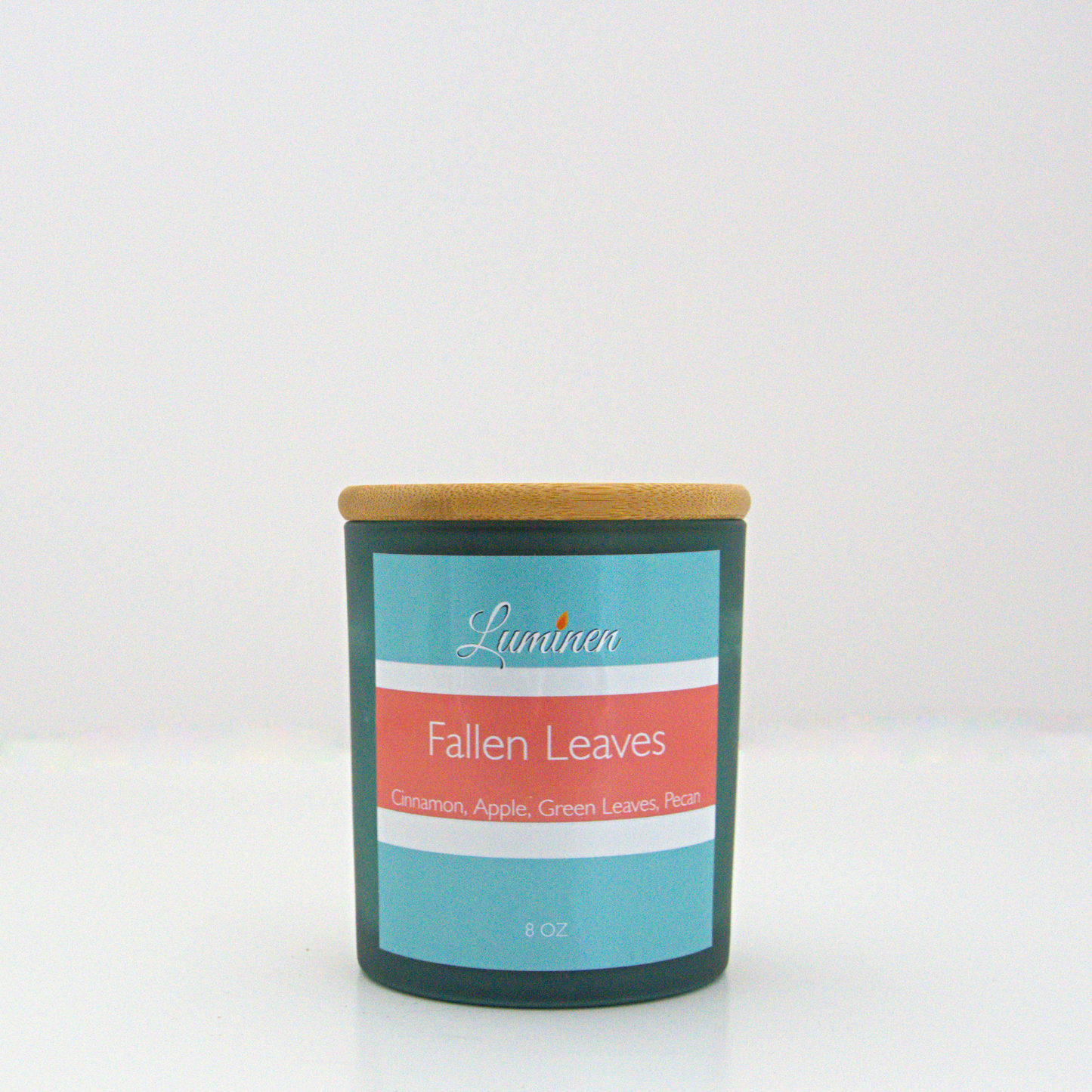 A 8oz fallen leaves frosted candle with a wooden lid sitting against a white background made by Eternel Luminen.