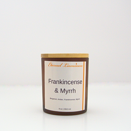 A 8 oz frankincense & myrrh frosted candle with a wooden lid sitting against a white background made by Eternel Luminen.