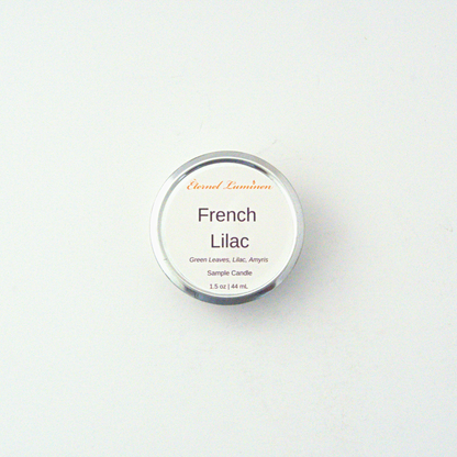 A 1.5oz French Lilac sample candle in a tin jar sitting against a white background made by Eternel Luminen