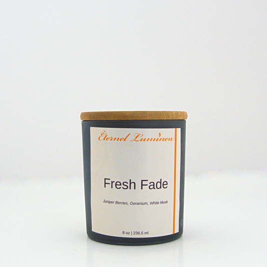 A 8 oz Fresh Fade frosted candle with a wooden lid sitting against a white background made by Eternel Luminen.