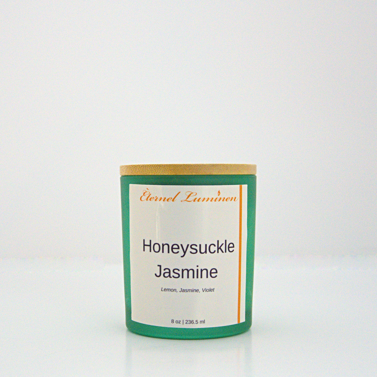 A 8 oz Honeysuckle Jasmine frosted candle with a wooden lid sitting against a white background made by Eternel Luminen.