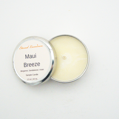 A 1.5oz Maui Breeze sample candle in a tin jar with the lid off sitting against a white background made by Eternel Luminen.