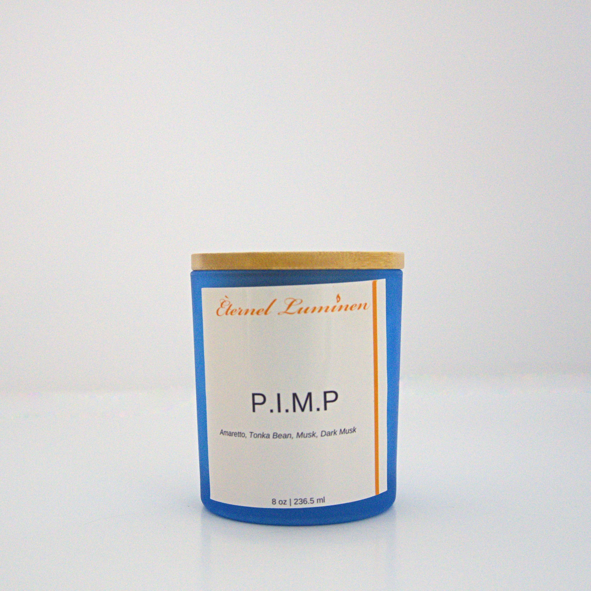 A 8 oz P.I.M.P frosted candle with a wooden lid sitting against a white background made by Eternel Luminen.