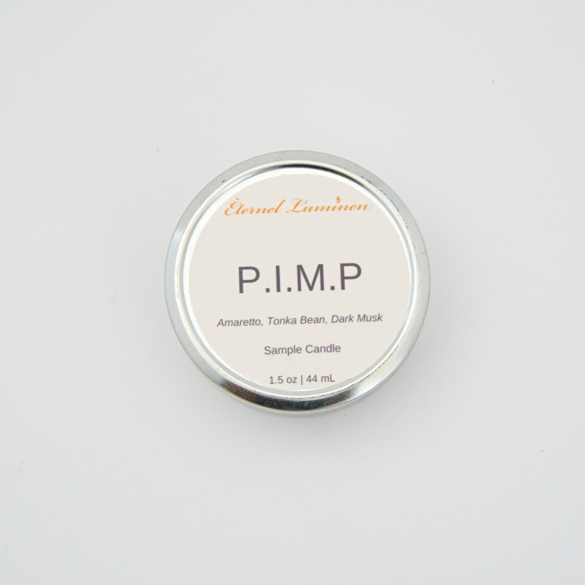 A 1.5oz P.I.M.P sample candle in a tin jar sitting against a white background 
