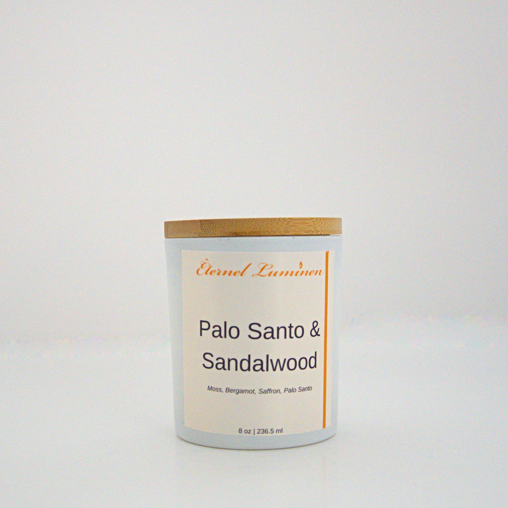 A 8 oz frosted Palo Santo & Sandalwood candle with a wooden lid sitting against a white background made by Eternel Luminen.