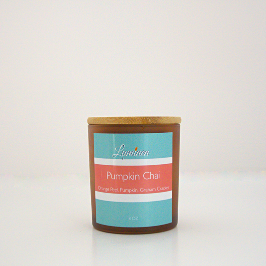 A 8 oz Pumpkin Chai frosted candle with a wooden lid sitting against a white background made by Eternel Luminen.