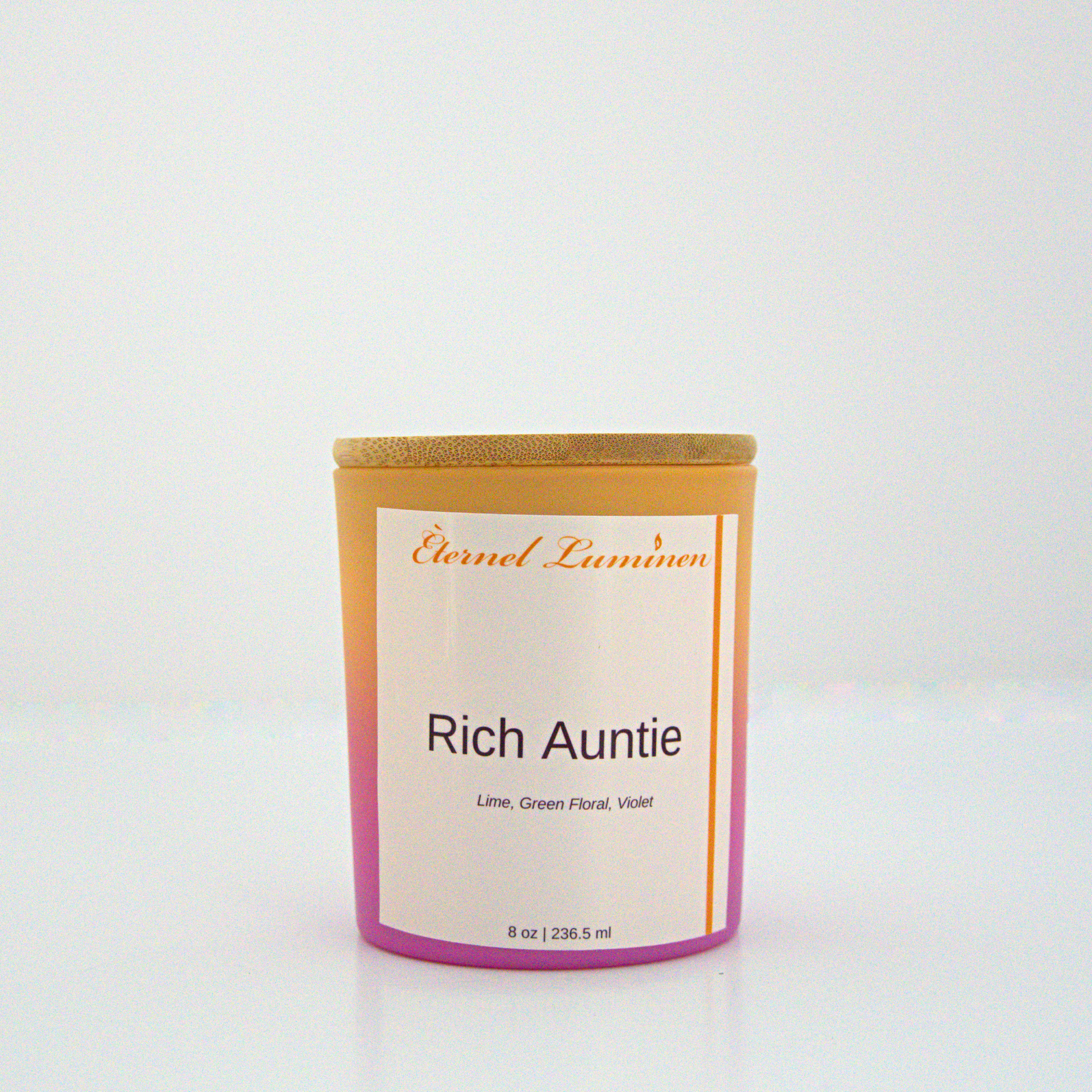 A 8 oz frosted Rich Auntie candle with a wooden lid sitting against a white background made by Eternel Luminen.