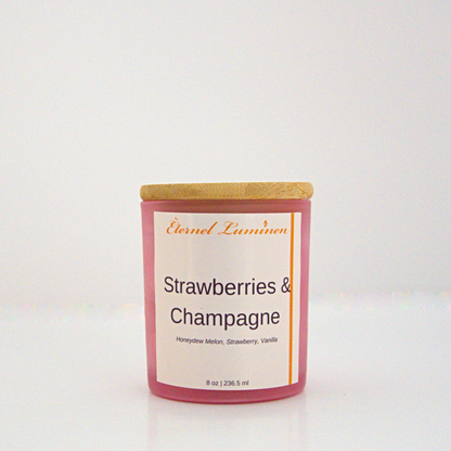 A 8 oz strawberry and champagne frosted candle with a wooden lid sitting against a white background made by Eternel Luminen.