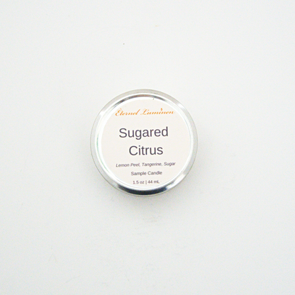 A 1.5oz Sugared Citrus sample candle in a tin jar sitting against a white background made by Eternel Luminen.