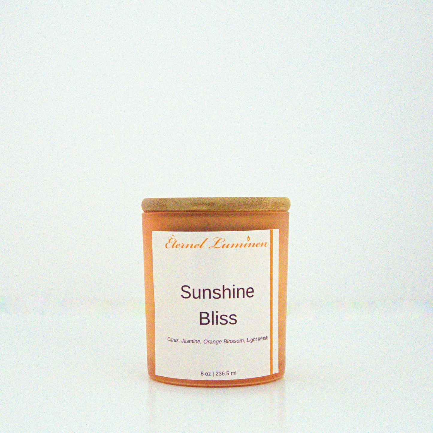 A 8 oz frosted Sunshine Bliss candle with a wooden lid sitting against a white background made by Eternel Luminen.