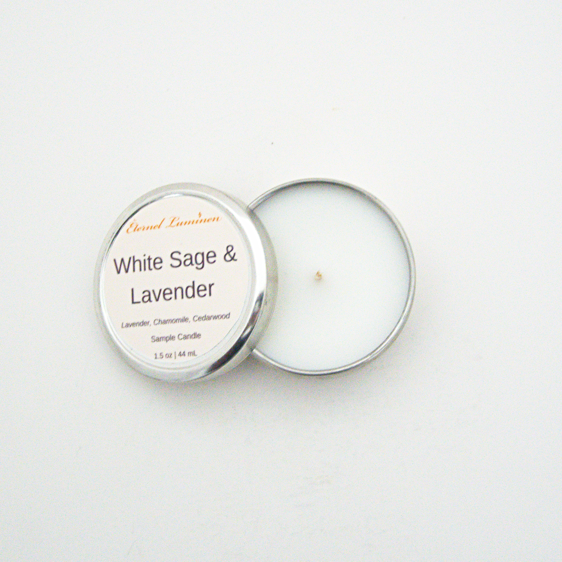 A 1.5oz White Sage & Lavender sample candle in a tin jar with the lid off sitting against a white background made by Eternel Luminen.