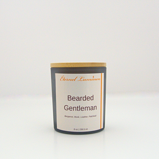 A 8 oz frosted Bearded Gentleman candle with a wooden lid sitting against a white background made by Eternel Luminen.